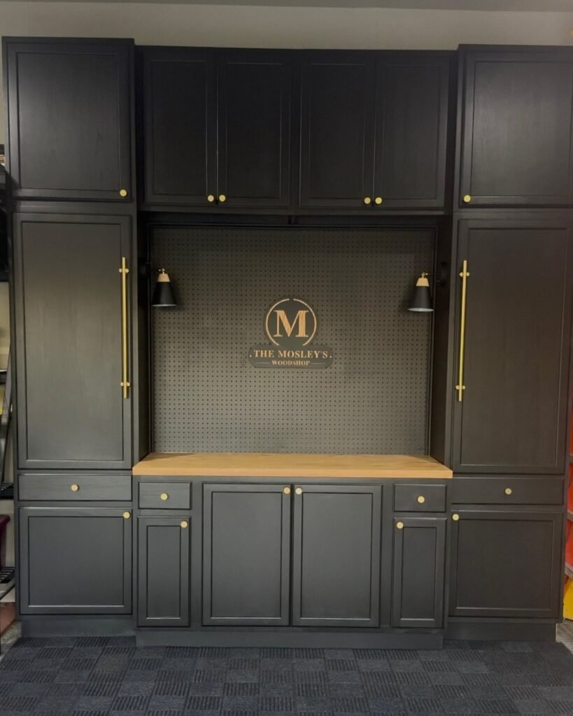 Dark charcoal built-in cabinets with a light wood countertop and a central pegboard backsplash.